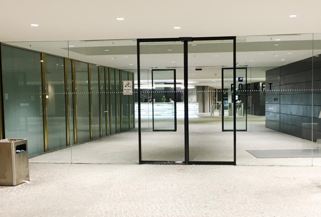 Full height office glass partition wall creating open plan workspace